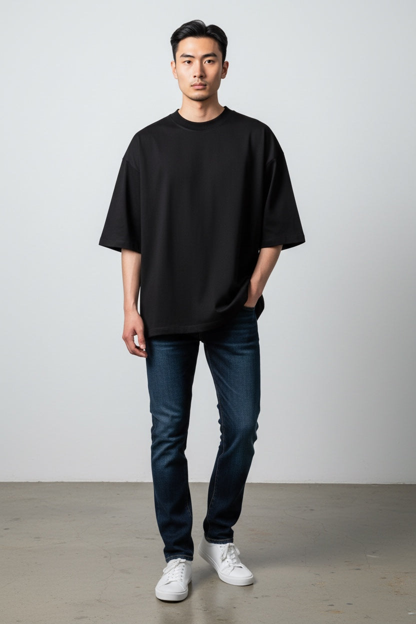 Pavel & Co Metropolis black boxy fit t-shirt with dropped shoulders worn by a man with dark denim jeans