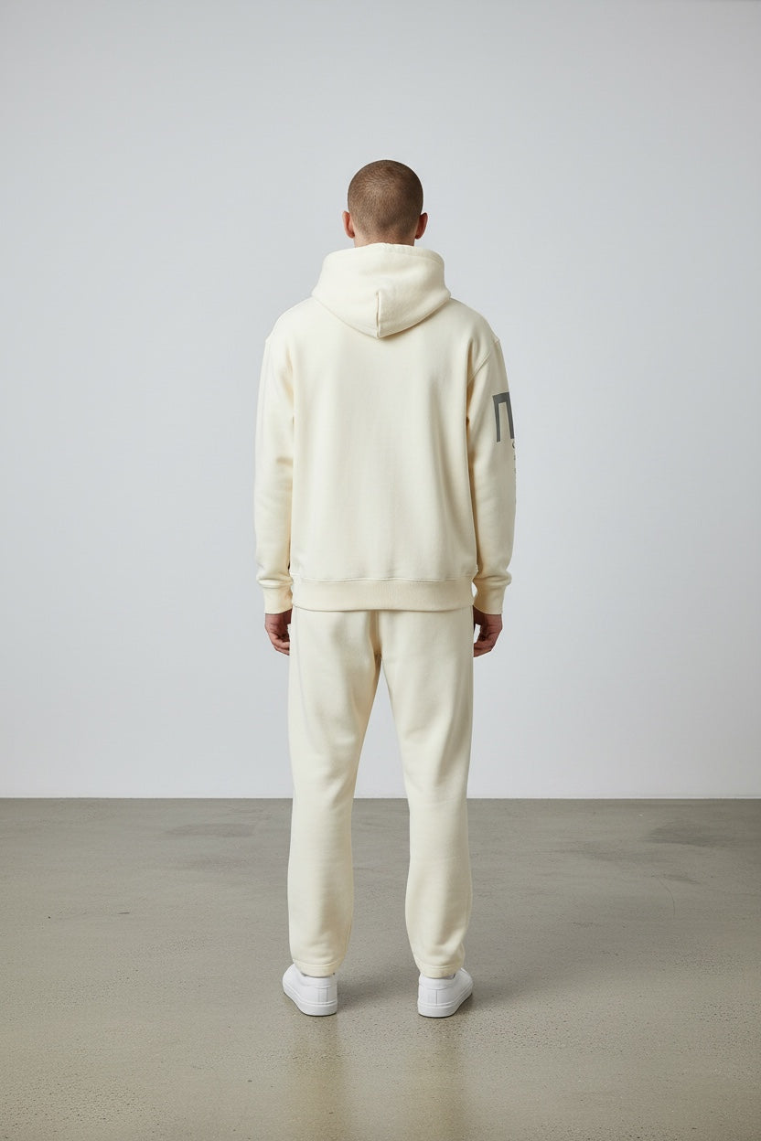 Back view of a man wearing a Pavel & Co cream oversized heavyweight cotton-blend hoodie and matching sweatpants.