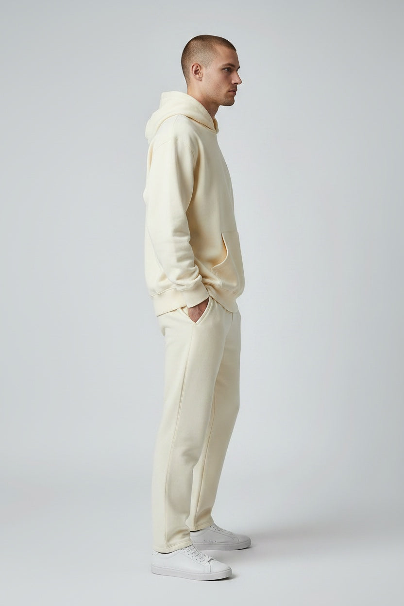 Pavel & Co oversized cream hoodie and matching sweatpants worn by a man in a side profile view.