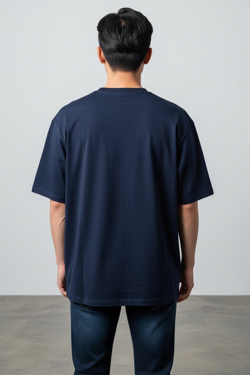 Back view of a man wearing a Pavel & Co navy blue heavyweight cotton French Terry boxy fit t-shirt with drop shoulders