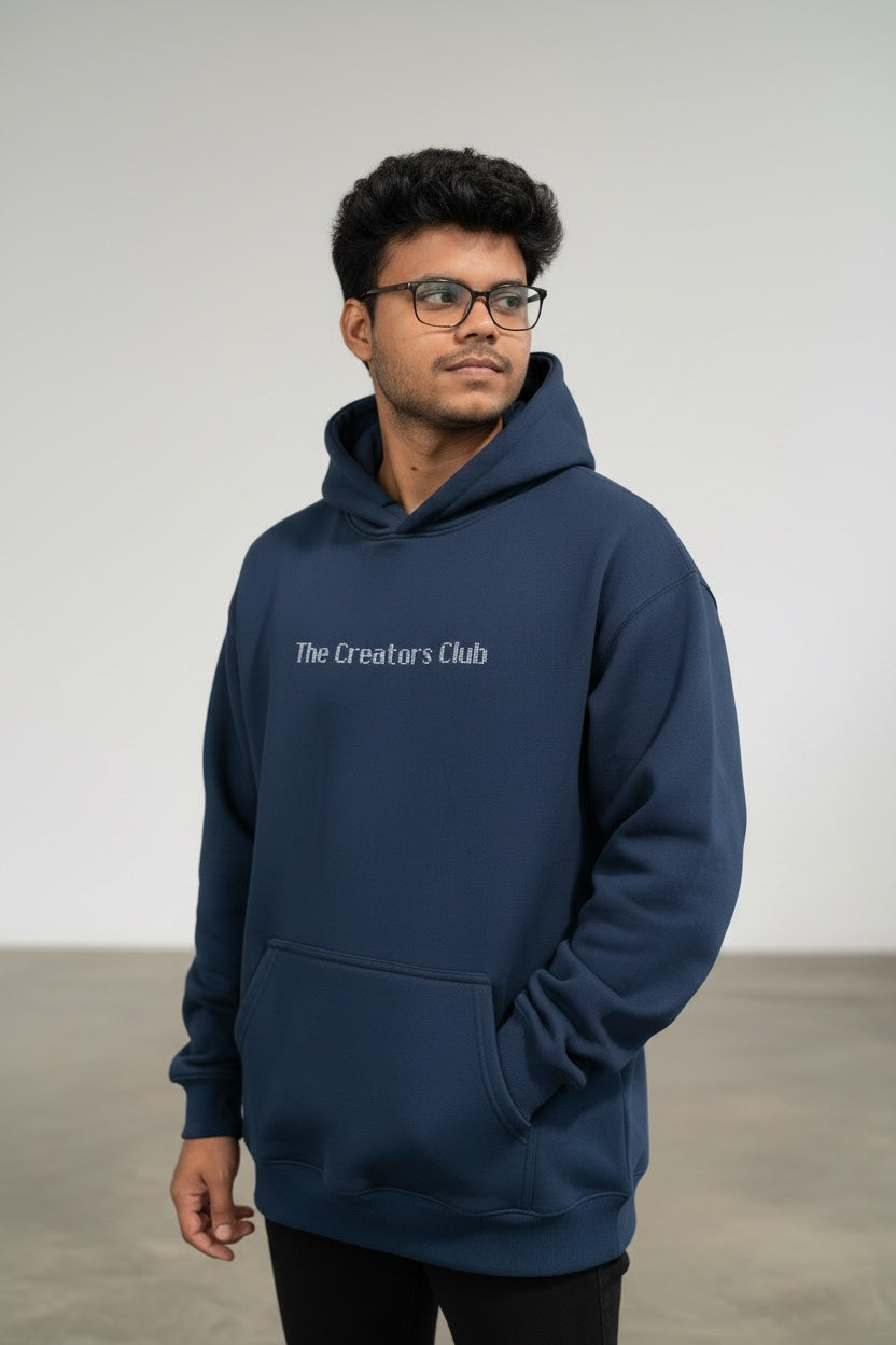 Pavel & Co navy oversized Creators Club hoodie with dropped shoulders and kangaroo pocket worn by a man.